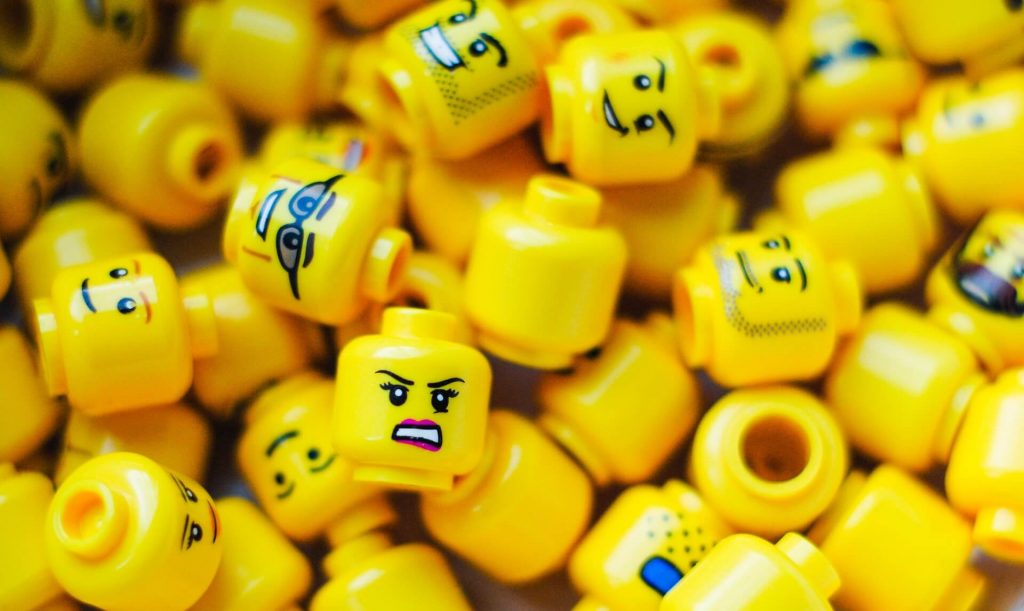A collection of Lego heads with various facial expressions, including happy, sad, surprised, and angry, showcasing the versatility of Lego characters.
